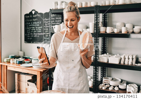 Happy woman, pottery and selfie in small business for social media, advertising or vlog at store. Female person or retail owner smiling with clay bowl for photo or online post on mobile smartphone Happy woman, pottery and selfie in small business for social media, advertising or vlog at store. Female person or retail owner smiling with clay bowl for photo or online post on mobile smartphone 134170411
