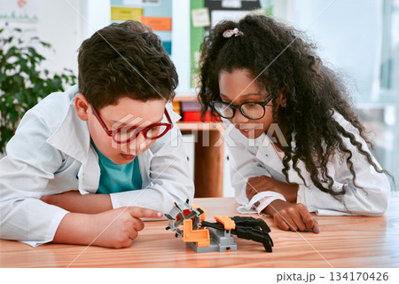 Engineering, learning and children building a robot hand together in a classroom at school and being curious. Clever, education and young engineer students working in a science class doing research Engineering, learning and children building a robot hand together in a classroom at school and being curious. Clever, education and young engineer students working in a science class doing research 134170426