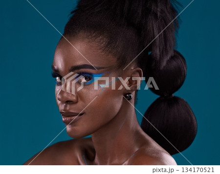 Portrait, hair and makeup with an african woman in studio on a blue background for beauty or cosmetics. Face, haircare and fashion with an attractive young female model posing for natural style Portrait, hair and makeup with an african woman in studio on a blue background for beauty or cosmetics. Face, haircare and fashion with an attractive young female model posing for natural style 134170521