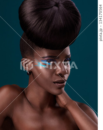 Portrait, cosmetics and hair care with an african woman in studio on a blue background for beauty or makeup. Eyeshadow, hairstyle and fashion with an attractive young female model at the salon 134170564