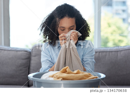 Smelling laundry, fresh and a woman on the sofa with a basket for organizing linen and clothes. Comfort, house and young cleaner with satisfaction from the smell of clean clothing in the living room 134170638