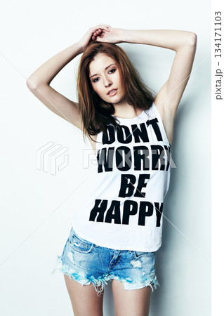 Portrait, young and a woman with a message on a shirt isolated on a white background in a studio. Fashion, stylish and a model with a tshirt and words of encouragement, empowerment and confidence 134171103