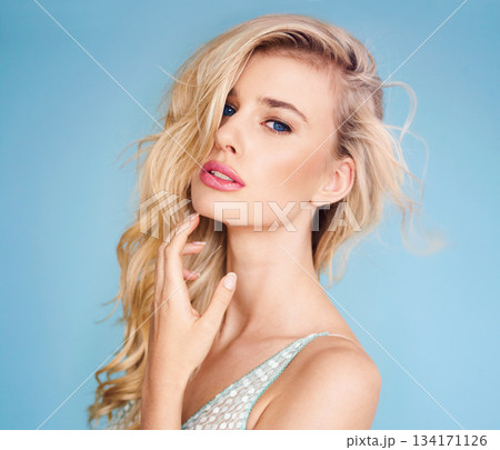 Portrait, beauty and hair with a woman in studio on a blue background for fashion or hairstyling at a salon. Face, shampoo or haircare with an attractive young female model posing for cosmetic makeup Portrait, beauty and hair with a woman in studio on a blue background for fashion or hairstyling at a salon. Face, shampoo or haircare with an attractive young female model posing for cosmetic makeup 134171126
