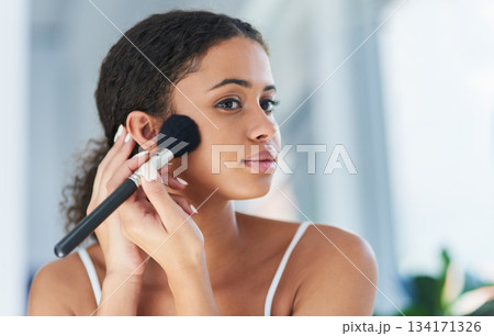 Beauty, makeup and woman with a cosmetic brush for a natural, skin and face in her bathroom. Young, glamour and beautiful female person with cosmetics powder for a morning routine in her apartment. Beauty, makeup and woman with a cosmetic brush for a natural, skin and face in her bathroom. Young, glamour and beautiful female person with cosmetics powder for a morning routine in her apartment. 134171326