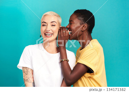 Whisper, secret and girl friends portrait with privacy, laugh and gossip in a studio. Blue background, women and smile of a female person with diversity and funny news telling a story and listening 134171382