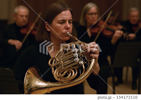 オーケストラでホルンを演奏している女性 134171510