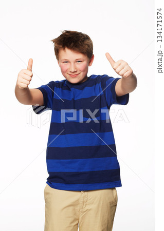 Portrait, thumbs up and smile of kid in studio isolated on a white background. Boy, hand gesture and child with like emoji for agreement, success or thank you, yes sign and winner, ok and approval. 134171574