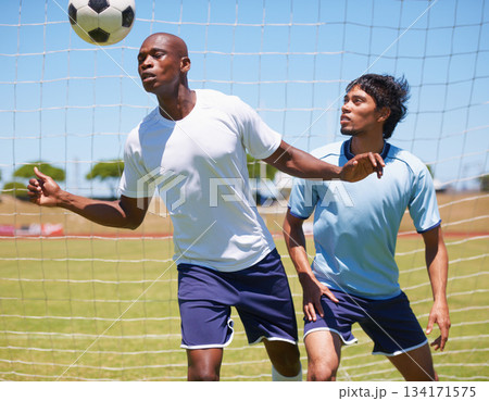 Men, sport and soccer with header, ball and contest for defender and striker on field for wellness. Man, football player and competition to stop goal, exercise or training together for health outdoor Men, sport and soccer with header, ball and contest for defender and striker on field for wellness. Man, football player and competition to stop goal, exercise or training together for health outdoor 134171575