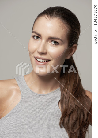 Happy woman, portrait and smile for fitness, exercise or cardio workout against a grey studio background. Face of fit, active and sweaty female person or model smiling in sportswear or exercising Happy woman, portrait and smile for fitness, exercise or cardio workout against a grey studio background. Face of fit, active and sweaty female person or model smiling in sportswear or exercising 134171670