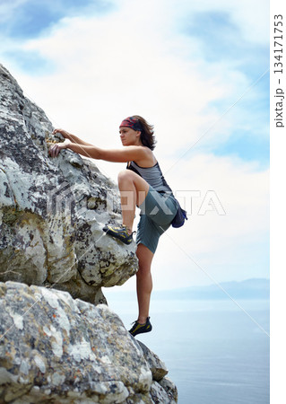 Woman, mountains and rock climbing on blue sky for sports, outdoor adventure and fitness challenge of strong athlete. Exercise, climber and hiking stone cliff with fearless courage on mockup space 134171753