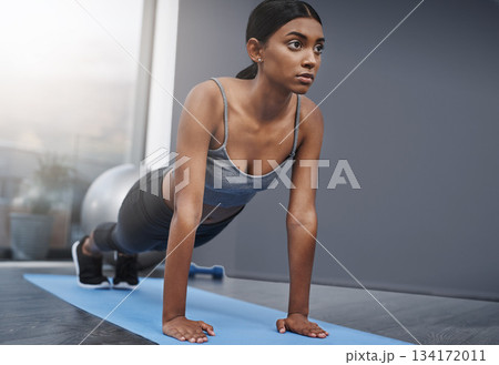 Push ups, fitness and woman in the gym training, exercise or workout for commitment to health and wellness. Yoga, serious and healthy female person start stretching body for morning sport performance 134172011