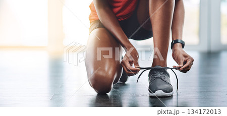 Shoes, fitness and woman tying laces to start exercise, workout or wellness sport in a gym for health performance. Sneakers, banner and hands of a healthy person or runner ready for training 134172013