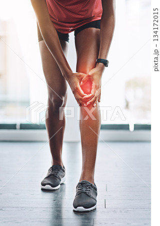 Hands, pain and knee injury with a woman in studio holding an injury to her joint while training for fitness. Accident, emergency and anatomy with a female athlete suffering from muscle inflammation 134172015