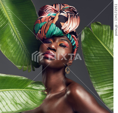 Leaf, makeup and portrait of black woman in studio for glow or natural cosmetics on grey background. Culture, beauty and face of African lady model with plant for cosmetology and jungle aesthetic 134172051