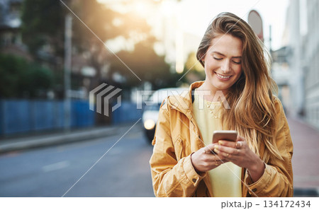 Woman, smile at smartphone with communication while in city, chat on social media and connectivity outdoor. Happy young person and student in urban street, text contact with mobile app and technology 134172434