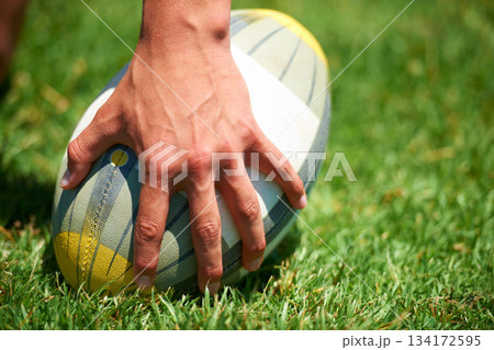 Rugby player, ball sports and hand of a man while outdoor on a pitch wit green grass or lawn. Male athlete person playing in sport competition, game or training match for fitness, workout or exercise Rugby player, ball sports and hand of a man while outdoor on a pitch wit green grass or lawn. Male athlete person playing in sport competition, game or training match for fitness, workout or exercise 134172595