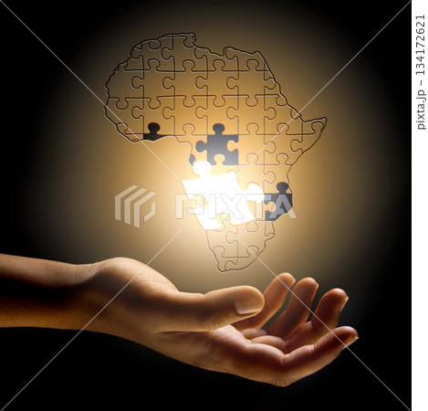 Closeup, Africa and hand with a puzzle, development and problem solving for growth, future and planning. Zoom, fingers or person with symbol, solidarity and support for global innovation and solution 134172621