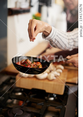 Hand, cooking and seasoning with a chef in the kitchen for meal preparation in a home for dinner. Healthy, diet and nutrition with food in a pan for wellness, hunger or satisfaction in a house Hand, cooking and seasoning with a chef in the kitchen for meal preparation in a home for dinner. Healthy, diet and nutrition with food in a pan for wellness, hunger or satisfaction in a house 134172676