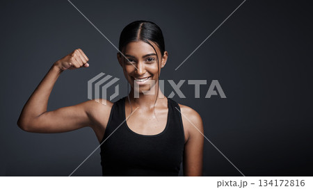 Portrait, smile and woman flexing bicep in studio isolated on a black background mockup space. Strong, happy and female athlete with muscle, arm strength and bodybuilder ready for fitness workout. 134172816