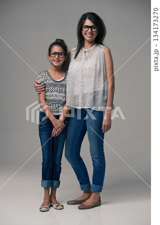 Portrait, mother and girl embrace in studio together on gray background or happy, preteen daughter and mommy with glasses. Family love, single mom and child or loving mama relationship with care 134173270