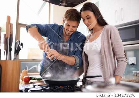 Happy couple, pan and cooking together in the kitchen with food or healthy ingredients for dinner at home. Man and woman smiling in happiness for meal preparation, lunch or frying vegetables on stove 134173276