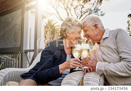 Love, cheers and wine, old couple celebrate romance or anniversary on patio of vacation home. Happiness, senior man and woman touching heads with champagne toast, smile and romantic date on holiday. Love, cheers and wine, old couple celebrate romance or anniversary on patio of vacation home. Happiness, senior man and woman touching heads with champagne toast, smile and romantic date on holiday. 134173456