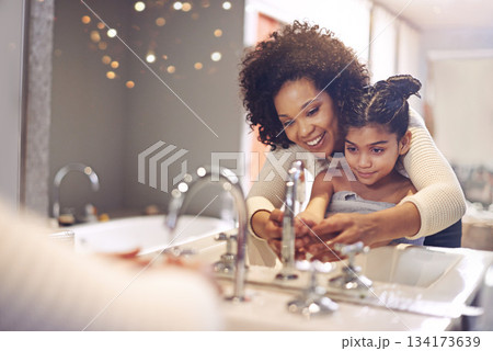 Water, cleaning and washing hands by mother and child in a bathroom for learning, hygiene and care. Basin, wash and hand protection by mom and girl together for prevention of bacteria, dirt and germs 134173639