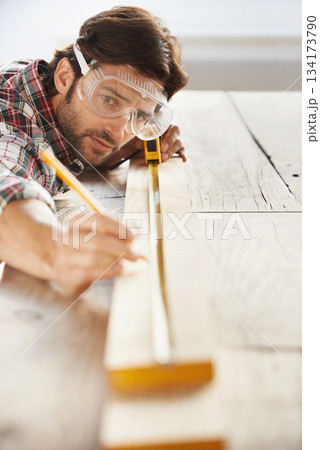 Wood, carpenter man building project and measurement with tape at construction site. Home renovation or furniture design, handyman working on maintenance at workshop and woodwork or handcraft 134173790