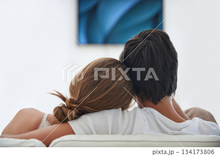 Back, relax and a couple watching tv on the sofa with affection, comfort and content at home. Calm, love and a man and woman sitting on the living room couch for a movie, film or show on television Back, relax and a couple watching tv on the sofa with affection, comfort and content at home. Calm, love and a man and woman sitting on the living room couch for a movie, film or show on television 134173806