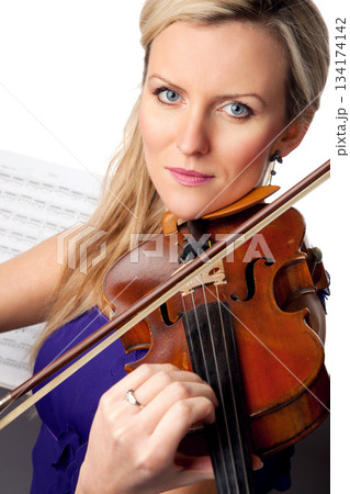 Sheet music, violin and portrait of woman in studio, professional orchestra musician on white background. Art, musical creativity and classical performance, face of concert violinist with instrument. Sheet music, violin and portrait of woman in studio, professional orchestra musician on white background. Art, musical creativity and classical performance, face of concert violinist with instrument. 134174142