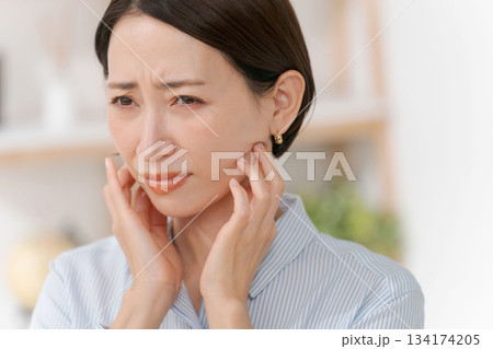 あごや首周りを触る女性 134174205