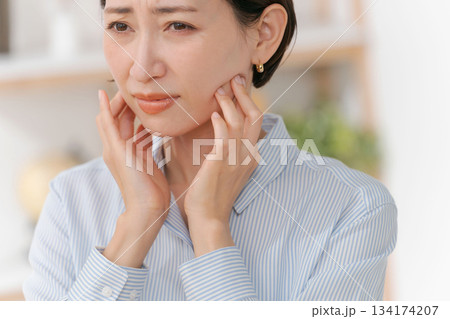 あごや首周りを触る女性 134174207