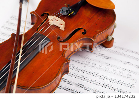 Sheet, music and classical with violin on paper for orchestra, vintage and antique instrument. Notes, retro art and culture with closeup of wooden fiddle for symphony, sound and theatre performance 134174232