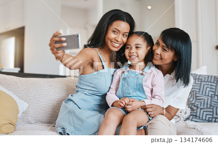 Selfie, grandmother and kid with mother in home living room, bonding or having fun. Family, happiness and girl with grandma and mama, care and enjoying time together while taking pictures on sofa. Selfie, grandmother and kid with mother in home living room, bonding or having fun. Family, happiness and girl with grandma and mama, care and enjoying time together while taking pictures on sofa. 134174606