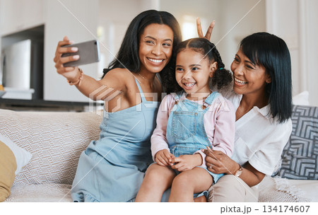 Peace sign selfie, grandmother and kid with mother in home living room, bonding or having fun. Family, smile and girl with grandma and mama, care or taking pictures on sofa with v hand emoji together Peace sign selfie, grandmother and kid with mother in home living room, bonding or having fun. Family, smile and girl with grandma and mama, care or taking pictures on sofa with v hand emoji together 134174607