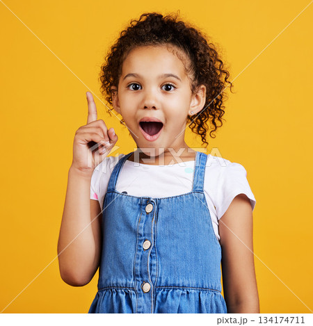 Idea, surprise and portrait of a girl pointing isolated on a yellow studio background with shock. Plan, knowledge and happy little child with bright ideas, wow and smart planning gesturing to space Idea, surprise and portrait of a girl pointing isolated on a yellow studio background with shock. Plan, knowledge and happy little child with bright ideas, wow and smart planning gesturing to space 134174711