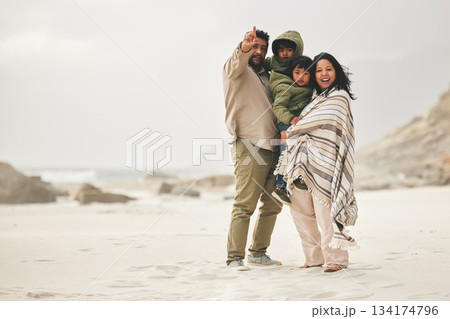Mother, father and children at the beach for family time in winter with love and care outdoor in nature. Man, woman and kids on a vacation, holiday or travel trip for bonding and pointing at mockup Mother, father and children at the beach for family time in winter with love and care outdoor in nature. Man, woman and kids on a vacation, holiday or travel trip for bonding and pointing at mockup 134174796
