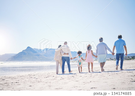 Holding hands, back and big family at the beach for walking, holiday and summer weekend by the ocean. Affection, support and parents, children and grandparents on a walk by the seaside for bonding Holding hands, back and big family at the beach for walking, holiday and summer weekend by the ocean. Affection, support and parents, children and grandparents on a walk by the seaside for bonding 134174885