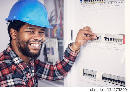 Black man in portrait, electrician and electricity fuse box, check power supply with maintenance on main circuit breaker. Engineer, technician and male worker with smile, handyman and electrical fix Black man in portrait, electrician and electricity fuse box, check power supply with maintenance on main circuit breaker. Engineer, technician and male worker with smile, handyman and electrical fix 134175290