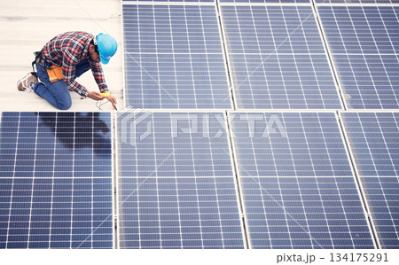 Black man, solar panel installation and renewable energy, sustainability and eco friendly technology. Maintenance, male engineer and infrastructure, electricity and top view with energy saving 134175291