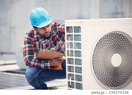 Black man, electrician with clipboard for air conditioner inspection, handyman working on rooftop with focus. Maintenance check, AC repair and male technician with power generator and service Black man, electrician with clipboard for air conditioner inspection, handyman working on rooftop with focus. Maintenance check, AC repair and male technician with power generator and service 134175336