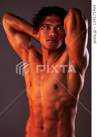 Man, sexy and torso body in studio for art, fitness or beauty of a person on a dark background. Face, strong muscle and male model with a six pack, glow and creative motivation for aesthetic backdrop 134175404
