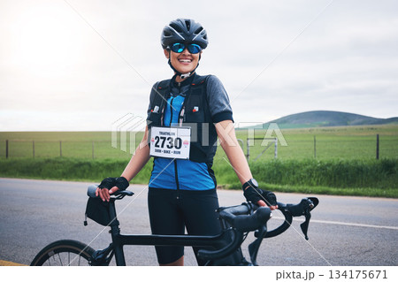 Portrait, cycling or happy woman in nature with bicycle for exercise, workout or training for triathlon fitness. Girl cyclist, sports or biker on break exercising for cardio endurance with smile 134175671