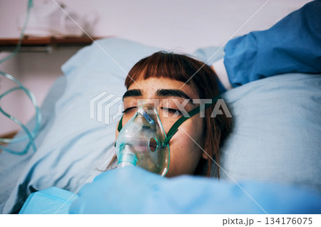 Healthcare, anesthesia and woman with an oxygen mask, recovery and operation in hospital bed. Female, lady and patients with breathing equipment, coma and cardiology with emergency and ventilation 134176075