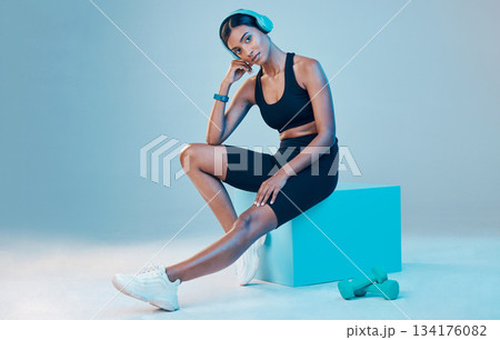Portrait, fitness and woman with wellness, exercise and training for energy, headphones and focus on a blue studio background. Face, female athlete and person with headset, workout goals and mindset Portrait, fitness and woman with wellness, exercise and training for energy, headphones and focus on a blue studio background. Face, female athlete and person with headset, workout goals and mindset 134176082