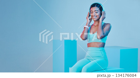 Mockup, fitness and woman with headphones, smile and exercise against a blue studio background. Female model, joy and person with headset, workout and streaming music with happiness, sports and radio Mockup, fitness and woman with headphones, smile and exercise against a blue studio background. Female model, joy and person with headset, workout and streaming music with happiness, sports and radio 134176084