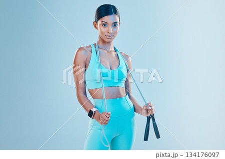 Fitness, skipping rope and mockup with a sports woman in studio on a blue background for health or wellness. Exercise, mindset and space with a young female athlete training for cardio or endurance Fitness, skipping rope and mockup with a sports woman in studio on a blue background for health or wellness. Exercise, mindset and space with a young female athlete training for cardio or endurance 134176097