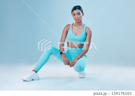 Fitness, portrait and focus with a sports woman in studio on a blue background for health or wellness. Exercise, mindset and serious with a female athlete training for a healthy body or lifestyle 134176103