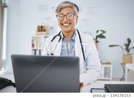 Woman doctor, laptop and happy in hospital office while working online for consultation or research. Medical professional female with internet for advice, healthcare and innovation or management 134176153
