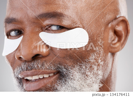 Skincare, collagen and eye mask for a portrait of black man with smile, happiness or anti ageing face treatment. Closeup dermatology, grooming or happy mature model with patches on eyes for skin care Skincare, collagen and eye mask for a portrait of black man with smile, happiness or anti ageing face treatment. Closeup dermatology, grooming or happy mature model with patches on eyes for skin care 134176411